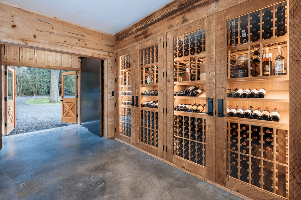 Aménagement d'une cave à vin moderne avec sol en béton ciré, un présentoir et un sol gris.