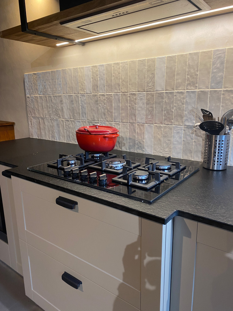 Foto di una cucina lineare country di medie dimensioni con lavello a doppia vasca, paraspruzzi beige, paraspruzzi con piastrelle in ceramica e top nero