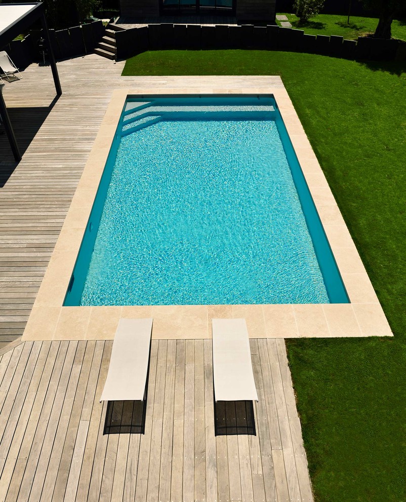 Inspiration for a mid-sized custom-shaped pool in Nantes with decking.