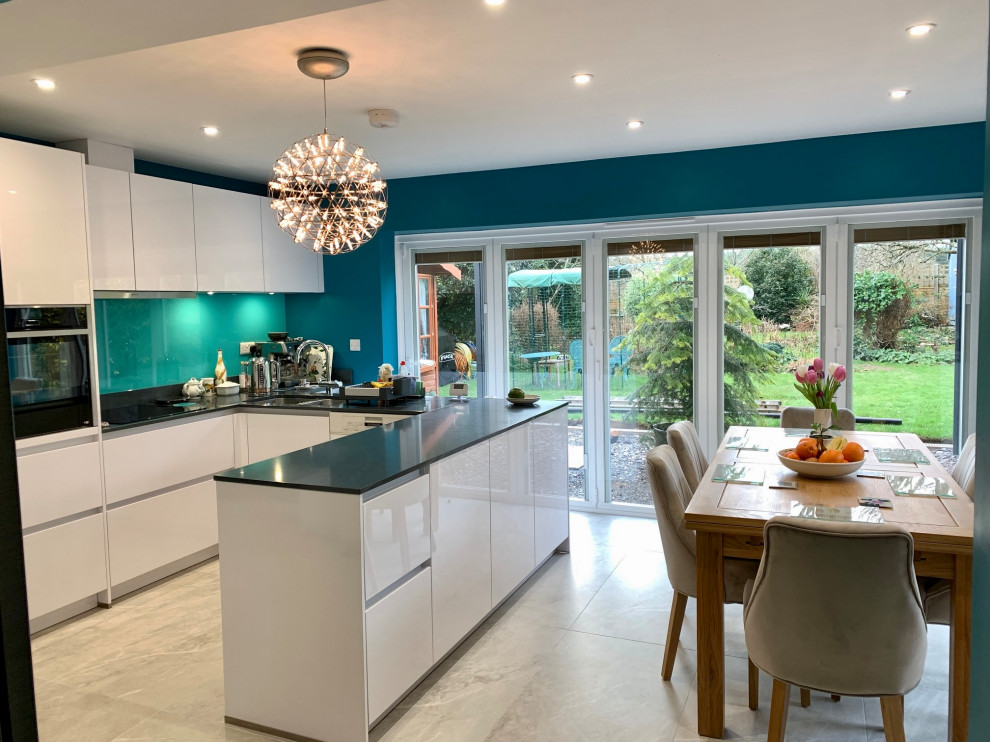 This is an example of a medium sized u-shaped kitchen/diner in Berkshire with flat-panel cabinets, white cabinets, quartz worktops and grey worktops.
