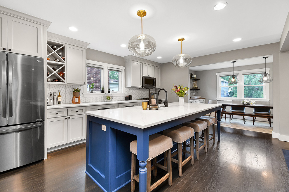 Kitchen - mid-sized transitional single-wall dark wood floor and brown floor kitchen idea in Columbus with an undermount sink, shaker cabinets, gray cabinets, quartz countertops, white backsplash, ceramic backsplash, stainless steel appliances, an island and white countertops