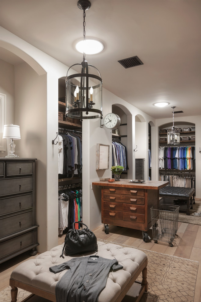 Example of a large cottage gender-neutral light wood floor and beige floor dressing room design in Phoenix with open cabinets