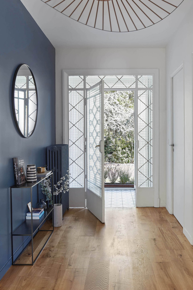 Ejemplo de puerta principal tradicional grande con paredes azules, suelo de madera clara, puerta simple y puerta azul
