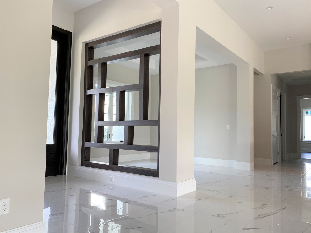 This is an example of a small transitional foyer in Miami with beige walls, porcelain floors, a double front door, a black front door and white floor.