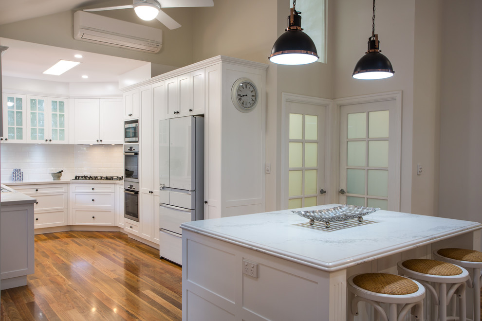 Inspiration for a large traditional u-shaped open plan kitchen in Brisbane with shaker cabinets, white cabinets, quartz benchtops, white splashback and with island.