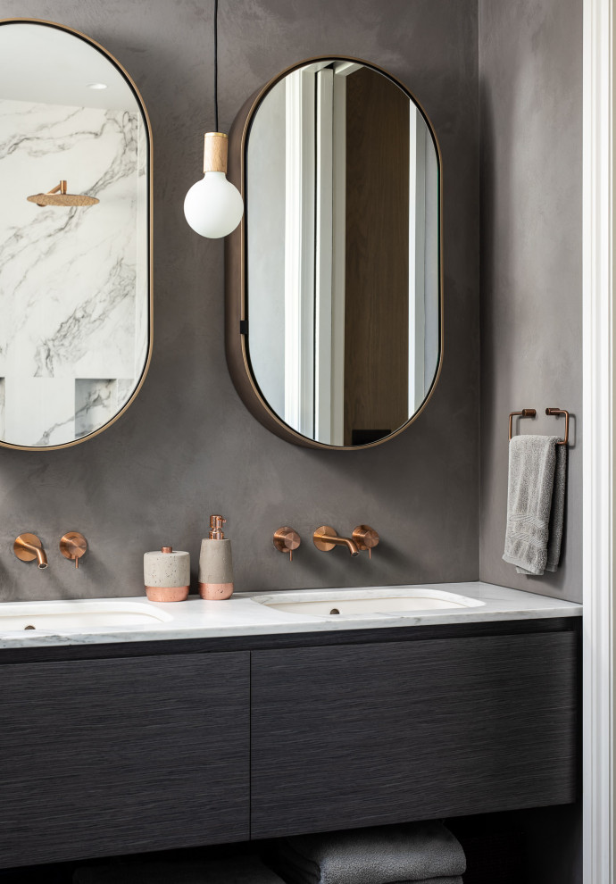 Photo of a mid-sized contemporary kids bathroom in London with recessed-panel cabinets, dark wood cabinets, a curbless shower, gray tile, grey walls, a drop-in sink, marble benchtops, white benchtops, a double vanity and a floating vanity.