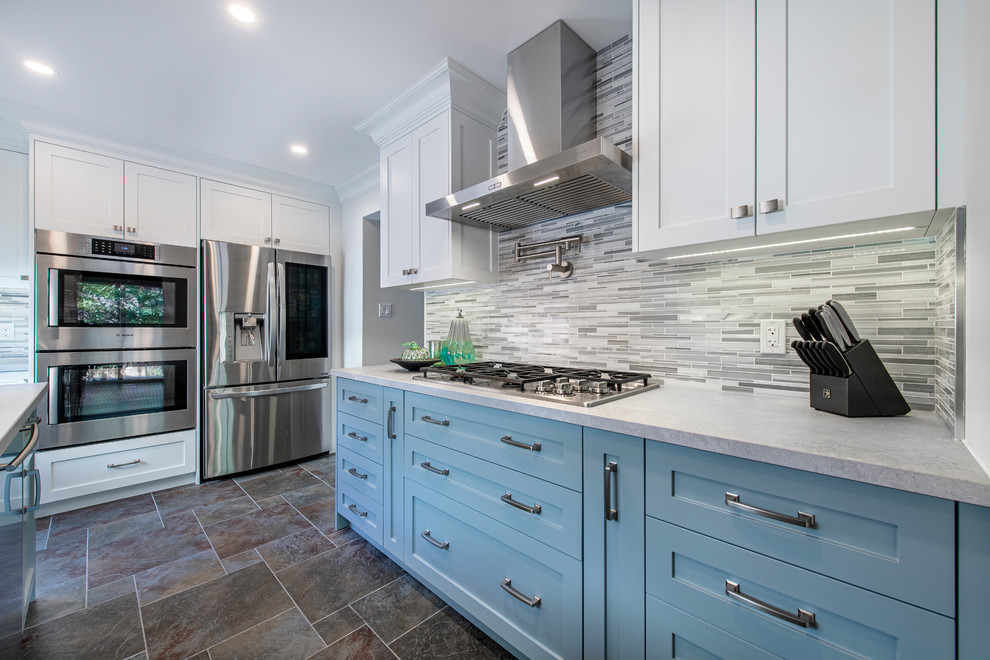 Eat-in kitchen - mid-sized transitional u-shaped slate floor and gray floor eat-in kitchen idea in Toronto with an undermount sink, recessed-panel cabinets, blue cabinets, solid surface countertops, gray backsplash, matchstick tile backsplash, stainless steel appliances, an island and white countertops