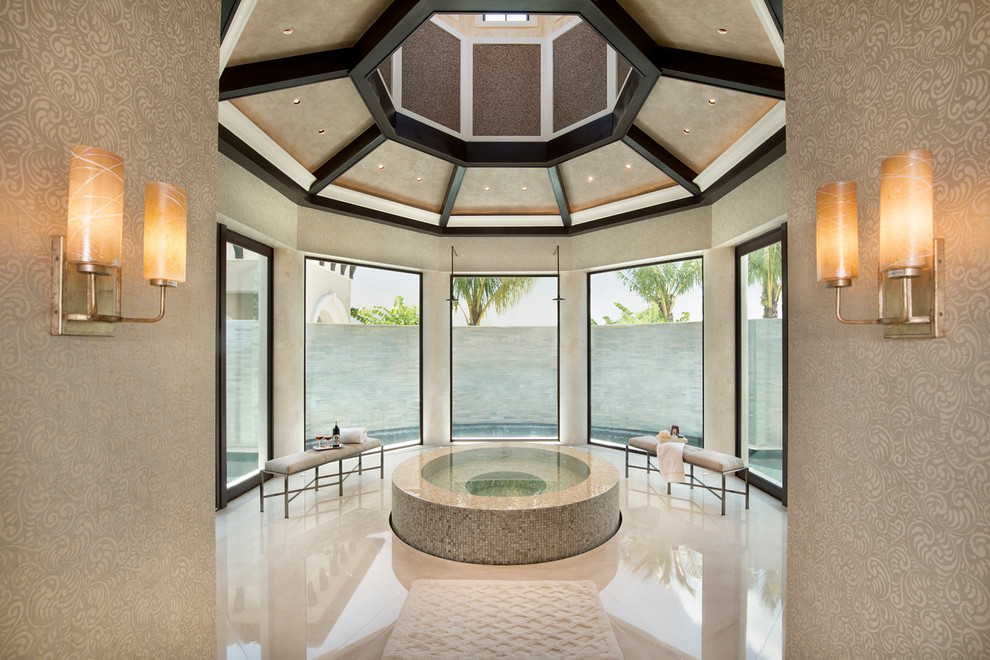 Mediterranean master bathroom in Miami with a hot tub, beige walls, limestone floors, beige tile and beige floor.