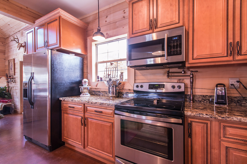 Mid-sized mountain style galley eat-in kitchen photo with an undermount sink, raised-panel cabinets, medium tone wood cabinets, granite countertops, wood backsplash, stainless steel appliances and an island