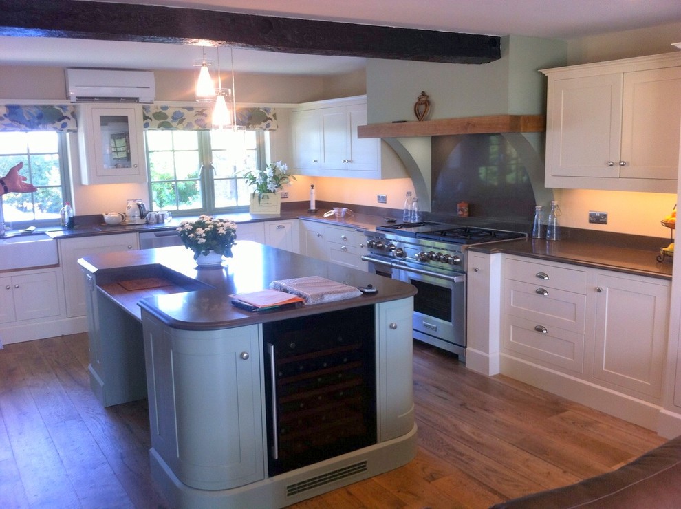 Photo of a traditional u-shaped kitchen in Berkshire with a double-bowl sink, grey splashback, medium hardwood floors and a peninsula.