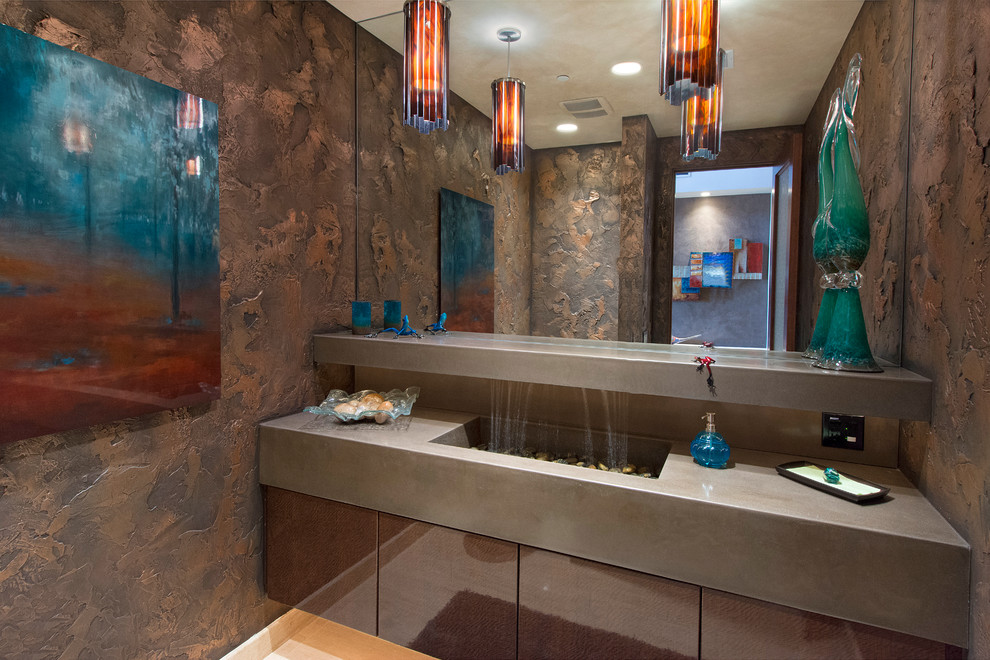 Photo of a contemporary powder room in Phoenix with an integrated sink, flat-panel cabinets, dark wood cabinets, brown walls and grey benchtops.
