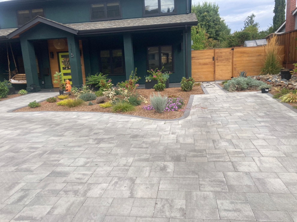 Large midcentury front yard driveway in San Francisco with with flowerbed, brick pavers and a wood fence.