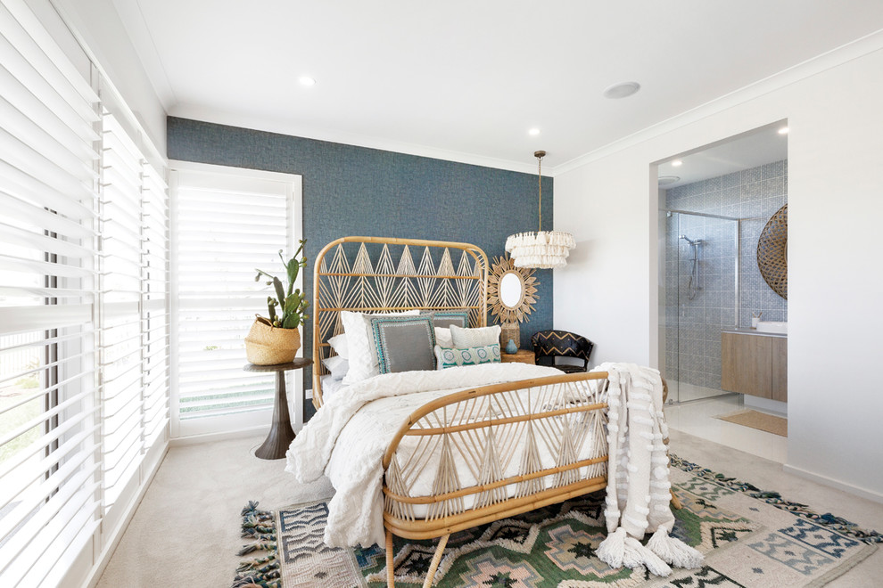 This is an example of a beach style master bedroom in Melbourne with blue walls, carpet and beige floor.