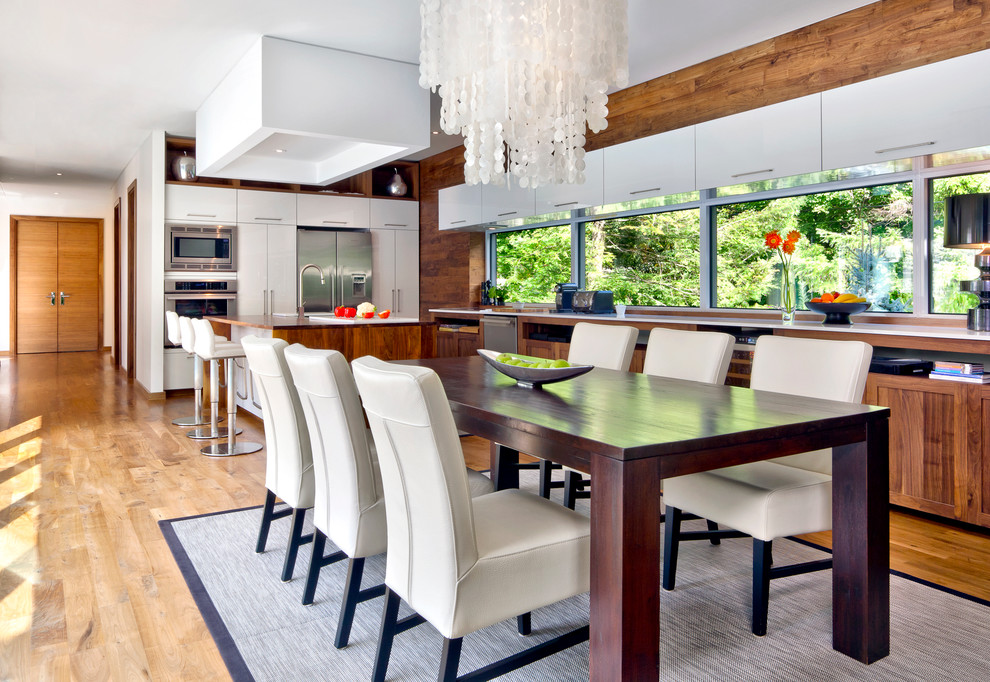 Photo of a contemporary open plan dining in Montreal with white walls and medium hardwood floors.