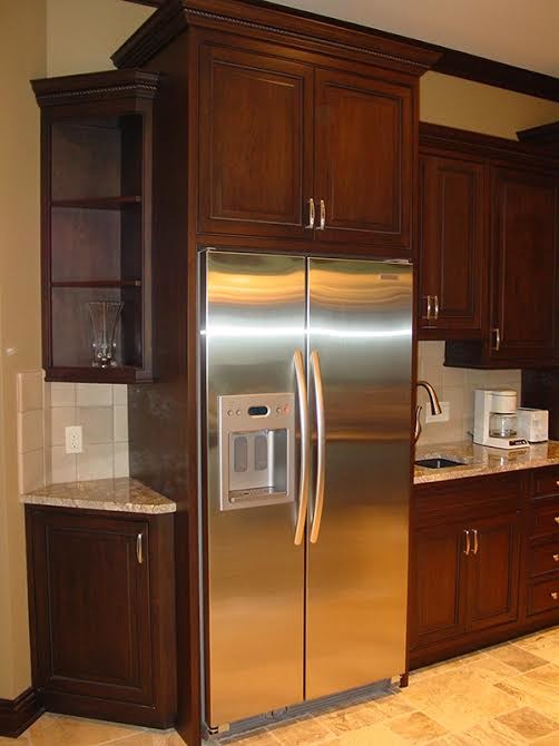 Photo of a mid-sized transitional l-shaped kitchen in Cedar Rapids with an undermount sink, recessed-panel cabinets, dark wood cabinets, beige splashback, ceramic splashback, stainless steel appliances, ceramic floors and beige floor.
