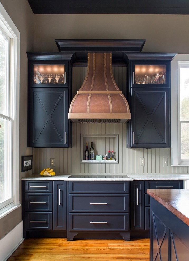 Inspiration for a country kitchen in Atlanta with recessed-panel cabinets, black cabinets, limestone benchtops, medium hardwood floors and with island.
