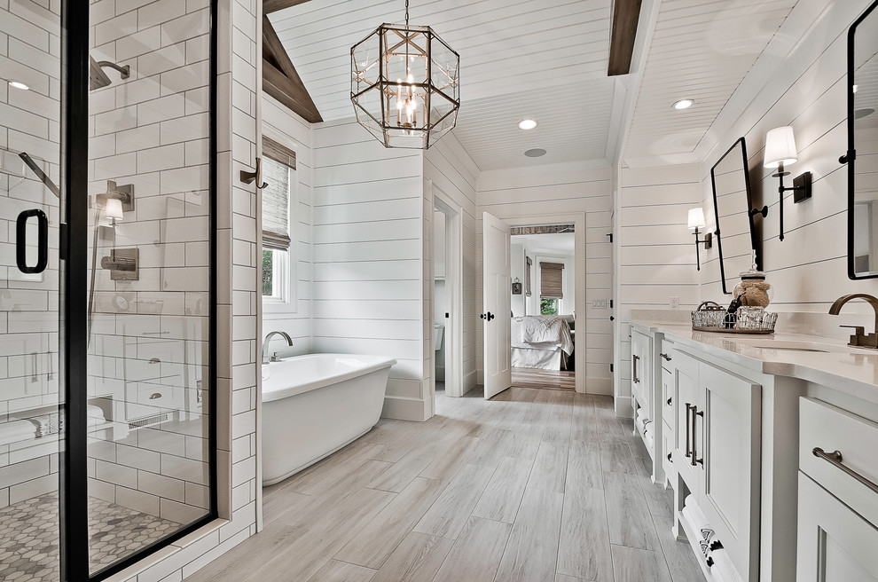 Design ideas for a large arts and crafts master bathroom in Little Rock with raised-panel cabinets, white cabinets, a freestanding tub, an alcove shower, a two-piece toilet, white tile, porcelain tile, white walls, ceramic floors, an undermount sink, engineered quartz benchtops, beige floor, a hinged shower door and white benchtops.