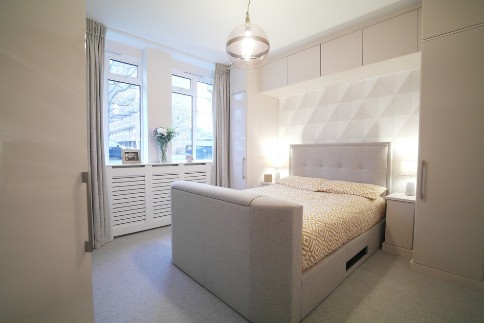 This is an example of a mid-sized contemporary master bedroom in London with grey walls and carpet.