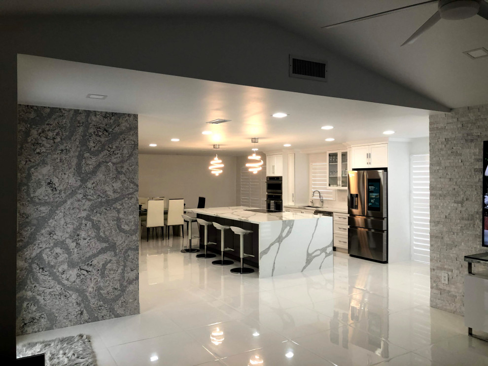 Inspiration for a transitional single-wall porcelain tile and white floor eat-in kitchen remodel in Miami with an undermount sink, shaker cabinets, white cabinets, quartz countertops, white backsplash, mosaic tile backsplash, stainless steel appliances and an island