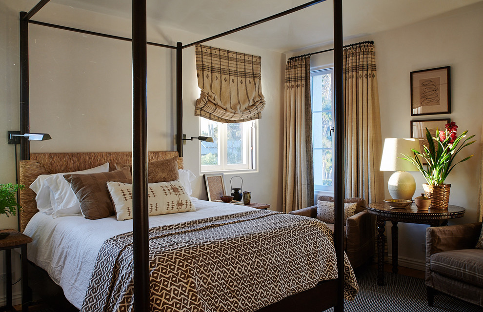 Photo of a mediterranean bedroom in Santa Barbara with beige walls, medium hardwood floors and brown floor.