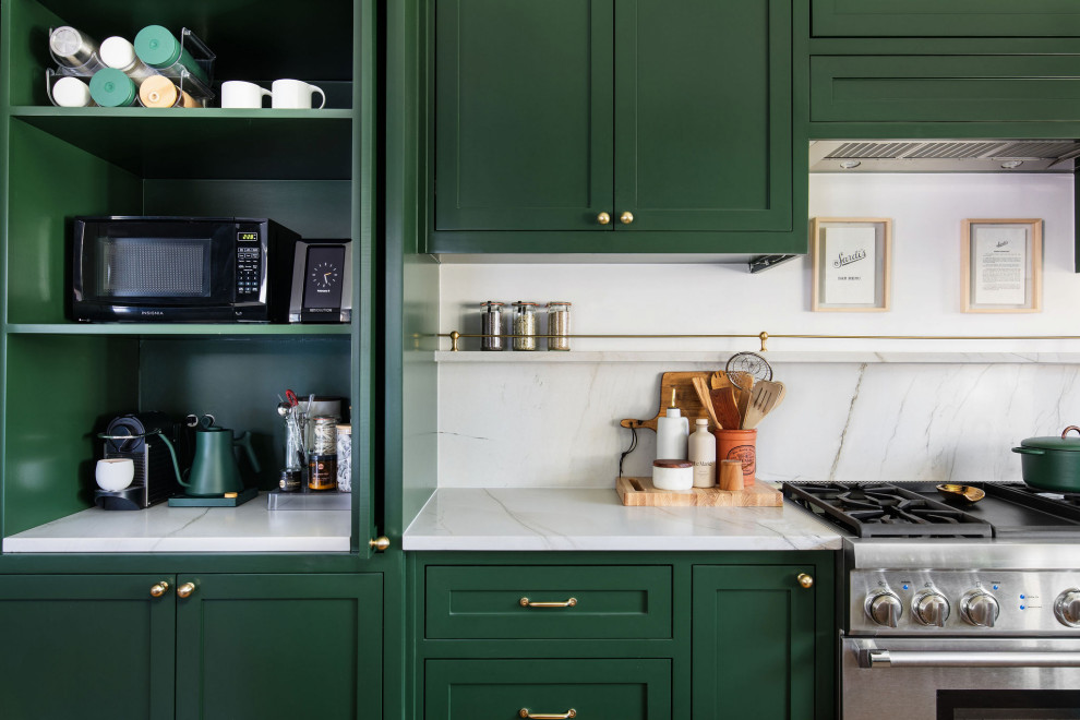 Example of a mid-sized transitional u-shaped medium tone wood floor and brown floor open concept kitchen design in Austin with an undermount sink, shaker cabinets, green cabinets, quartzite countertops, white backsplash, stone slab backsplash, stainless steel appliances, an island and white countertops