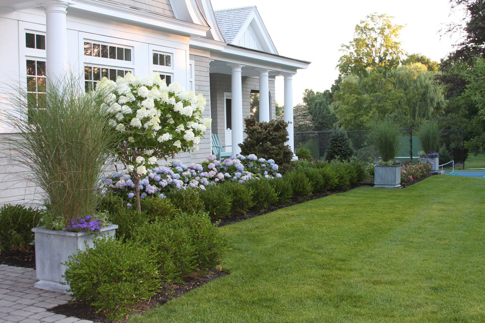 This is an example of a large beach style front yard partial sun garden in Boston.