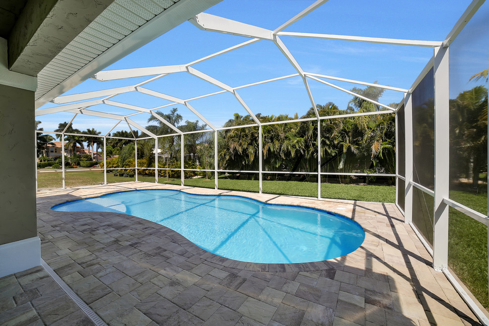 Example of a mid-sized transitional backyard brick and kidney-shaped pool design