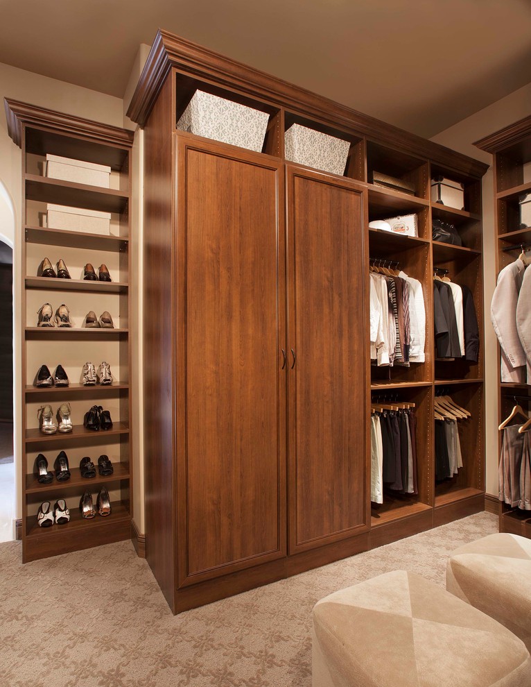 Large traditional gender-neutral walk-in wardrobe in Denver with recessed-panel cabinets, medium wood cabinets and carpet.