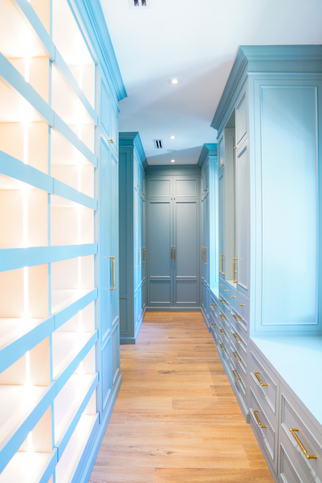 Inredning av ett klassiskt walk-in-closet, med luckor med upphöjd panel och blå skåp