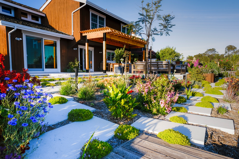 Diseño de jardín de secano actual grande en otoño en patio trasero con pérgola, exposición total al sol y adoquines de hormigón