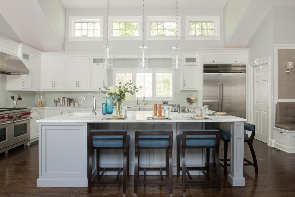Open concept kitchen - large transitional l-shaped dark wood floor and brown floor open concept kitchen idea in DC Metro with a farmhouse sink, shaker cabinets, white cabinets, gray backsplash, stainless steel appliances, an island, marble countertops and ceramic backsplash