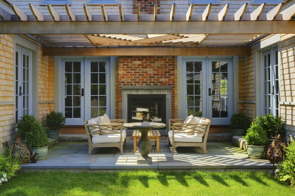 Design ideas for a transitional patio in Boston with a fire feature and a pergola.