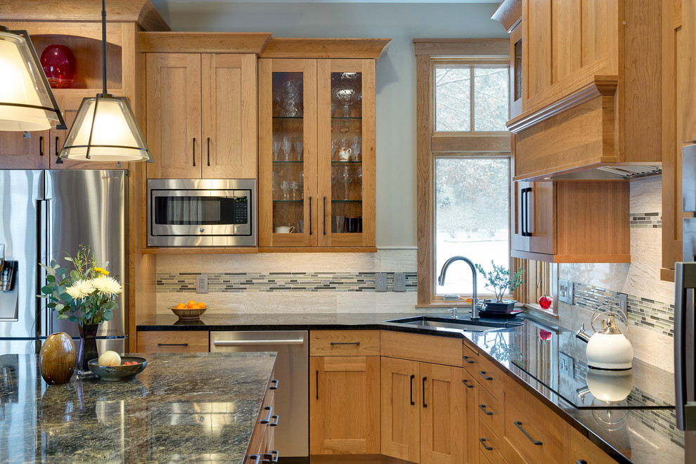 Photo of a large transitional l-shaped eat-in kitchen in Minneapolis with an undermount sink, recessed-panel cabinets, medium wood cabinets, granite benchtops, multi-coloured splashback, stainless steel appliances, medium hardwood floors, with island and matchstick tile splashback.