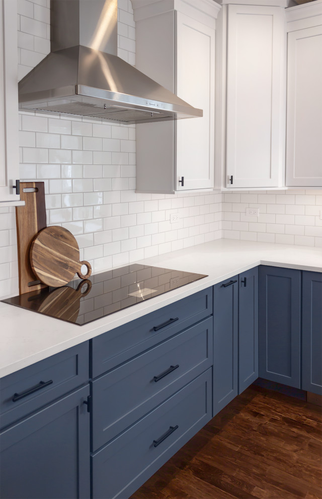 Inredning av ett klassiskt mellanstort vit vitt kök och matrum, med skåp i shakerstil, blå skåp, bänkskiva i kvartsit, vitt stänkskydd, stänkskydd i keramik, rostfria vitvaror och en köksö