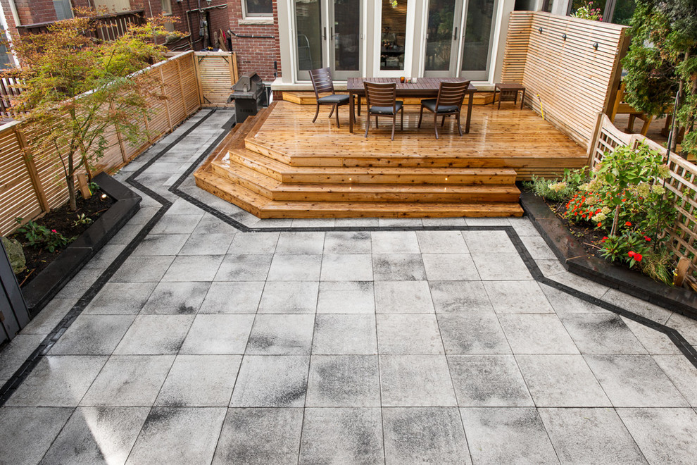 Inspiration for a mid-sized modern courtyard patio in Toronto with an outdoor kitchen, tile and no cover.