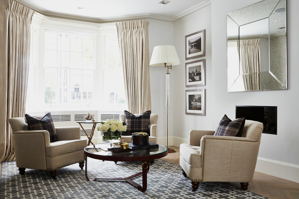 Transitional formal living room in London with grey walls, light hardwood floors, a ribbon fireplace and no tv.