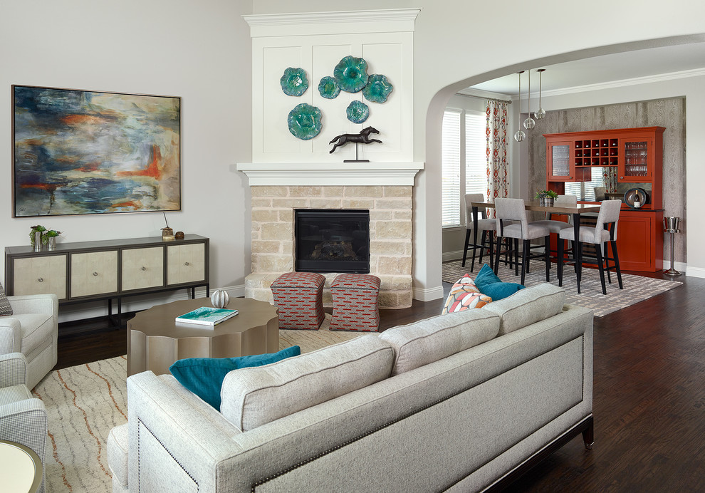 This is an example of a mid-sized transitional open concept family room in Dallas with a home bar, grey walls, medium hardwood floors, a corner fireplace, a stone fireplace surround, no tv and brown floor.