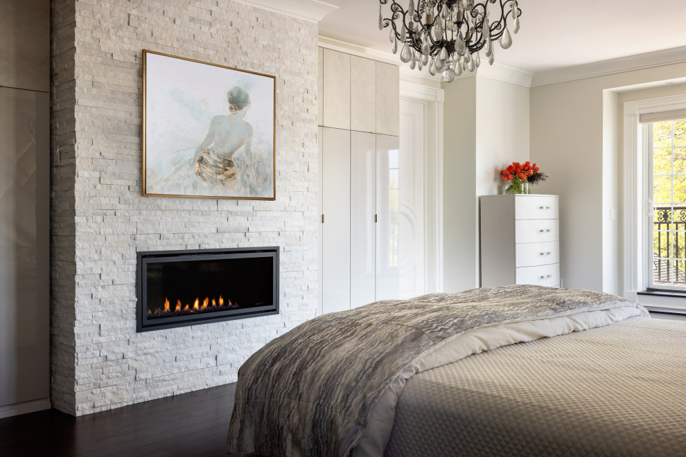 Photo of a large modern master bedroom in New York with beige walls, dark hardwood floors, a ribbon fireplace, a brick fireplace surround and brown floor.