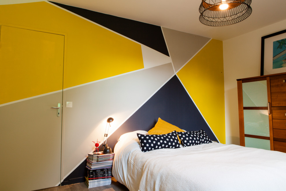 Inspiration for a mid-sized contemporary master bedroom in Lille with yellow walls, laminate floors, no fireplace and grey floor.