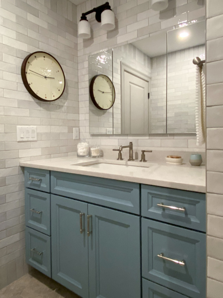 Photo of a traditional shower room bathroom in Boston with flat-panel cabinets, blue cabinets, an alcove shower, a two-piece toilet, beige tiles, ceramic tiles, beige walls, limestone flooring, a submerged sink, engineered stone worktops, beige floors, a hinged door, beige worktops, a single sink and a built in vanity unit.
