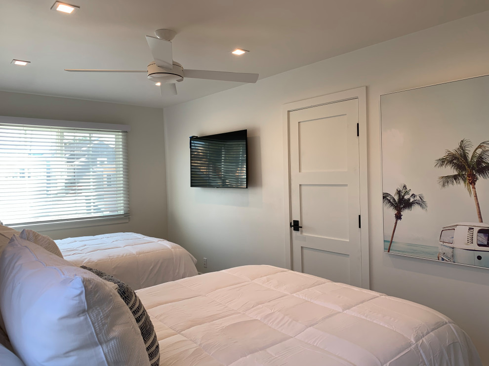 Ispirazione per una piccola camera degli ospiti stile marino con pareti blu, pavimento in vinile, pavimento beige e carta da parati