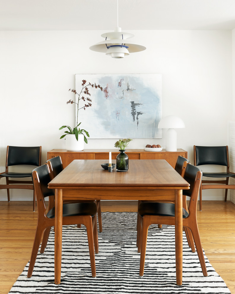 Photo of a medium sized retro dining room in San Francisco with white walls, medium hardwood flooring and brown floors.