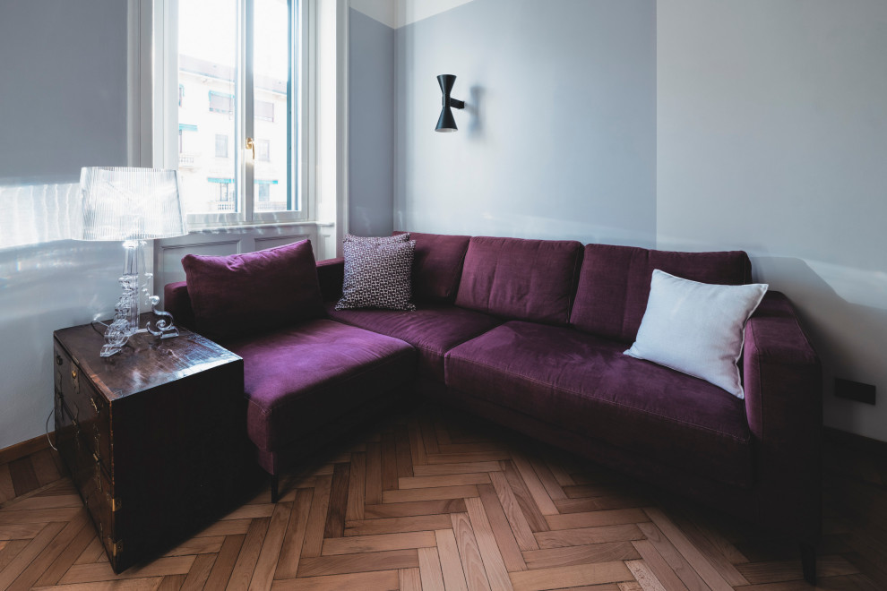 Modelo de sala de estar con biblioteca cerrada bohemia de tamaño medio con paredes grises, suelo de madera clara, televisor independiente y suelo beige