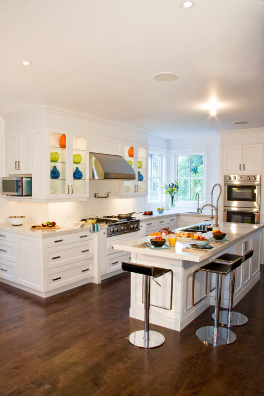 Eat-in kitchen - large contemporary l-shaped medium tone wood floor and brown floor eat-in kitchen idea in Toronto with an undermount sink, shaker cabinets, white cabinets, granite countertops, white backsplash, stainless steel appliances, an island and white countertops