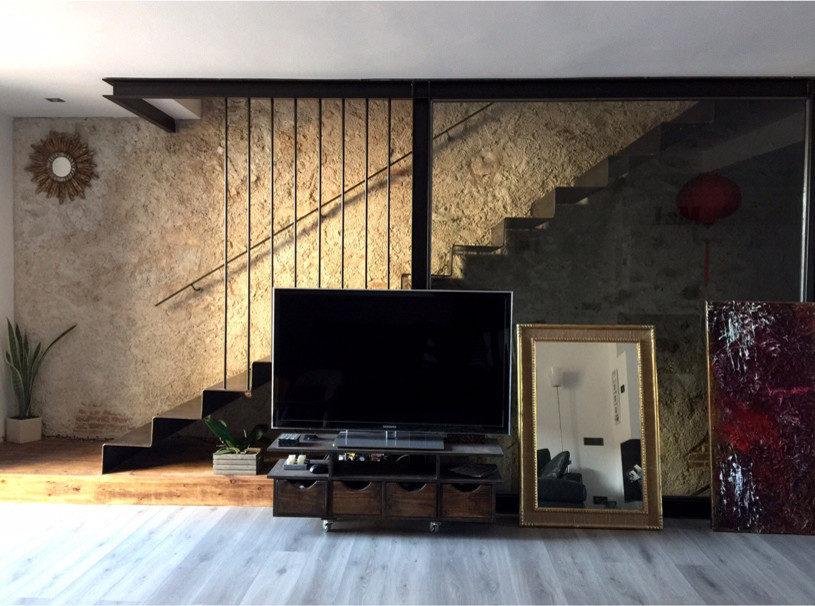 Modelo de sala de estar tipo loft urbana de tamaño medio con suelo de madera en tonos medios, estufa de leña, marco de chimenea de metal y suelo gris