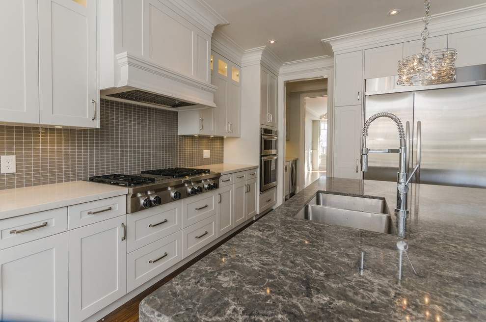 Example of a mid-sized transitional u-shaped medium tone wood floor eat-in kitchen design in Toronto with a double-bowl sink, raised-panel cabinets, white cabinets, granite countertops, gray backsplash, mosaic tile backsplash, stainless steel appliances and an island