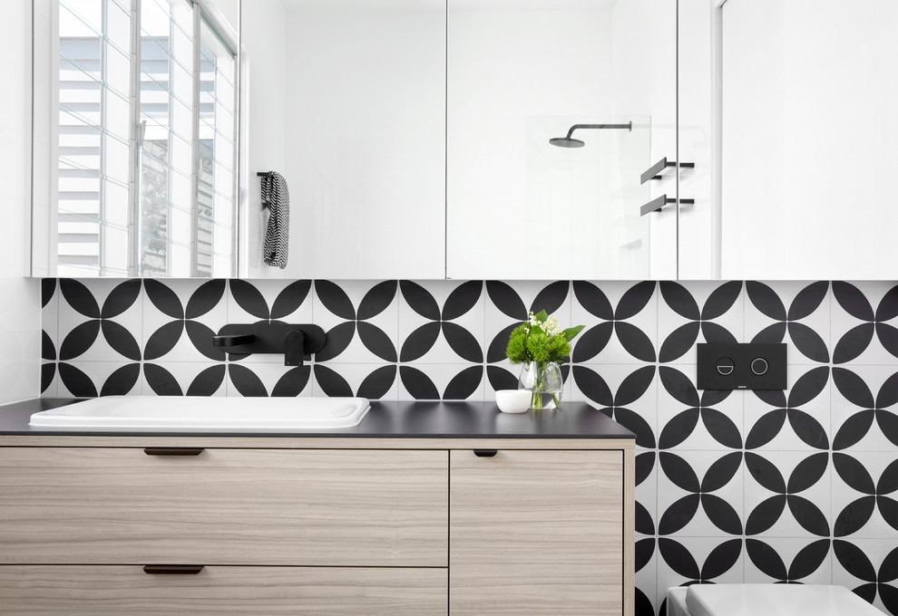 Design ideas for a mid-sized contemporary master bathroom in Melbourne with beaded inset cabinets, light wood cabinets, a freestanding tub, an open shower, multi-coloured tile, mosaic tile, a drop-in sink, solid surface benchtops and black benchtops.