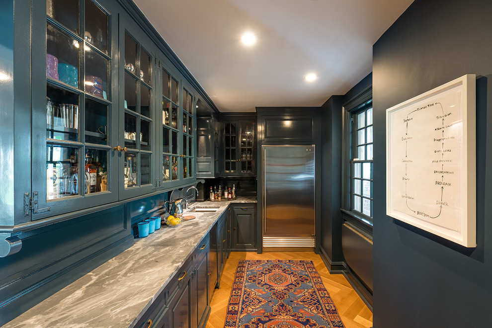 Large traditional u-shaped eat-in kitchen in Minneapolis with an undermount sink, raised-panel cabinets, blue cabinets, marble benchtops, white splashback, stone tile splashback, panelled appliances, light hardwood floors and with island.