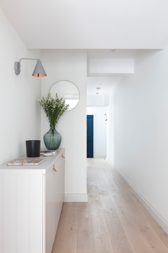 Design ideas for a large scandinavian hallway in London with white walls, light hardwood floors and beige floor.