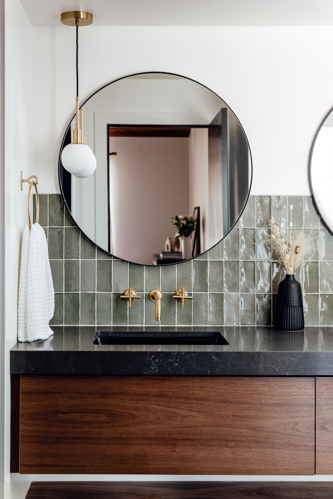 This is an example of a master bathroom in Salt Lake City with flat-panel cabinets, brown cabinets, green tile, white walls, an undermount sink, grey floor, a hinged shower door, black benchtops, a double vanity and a floating vanity.